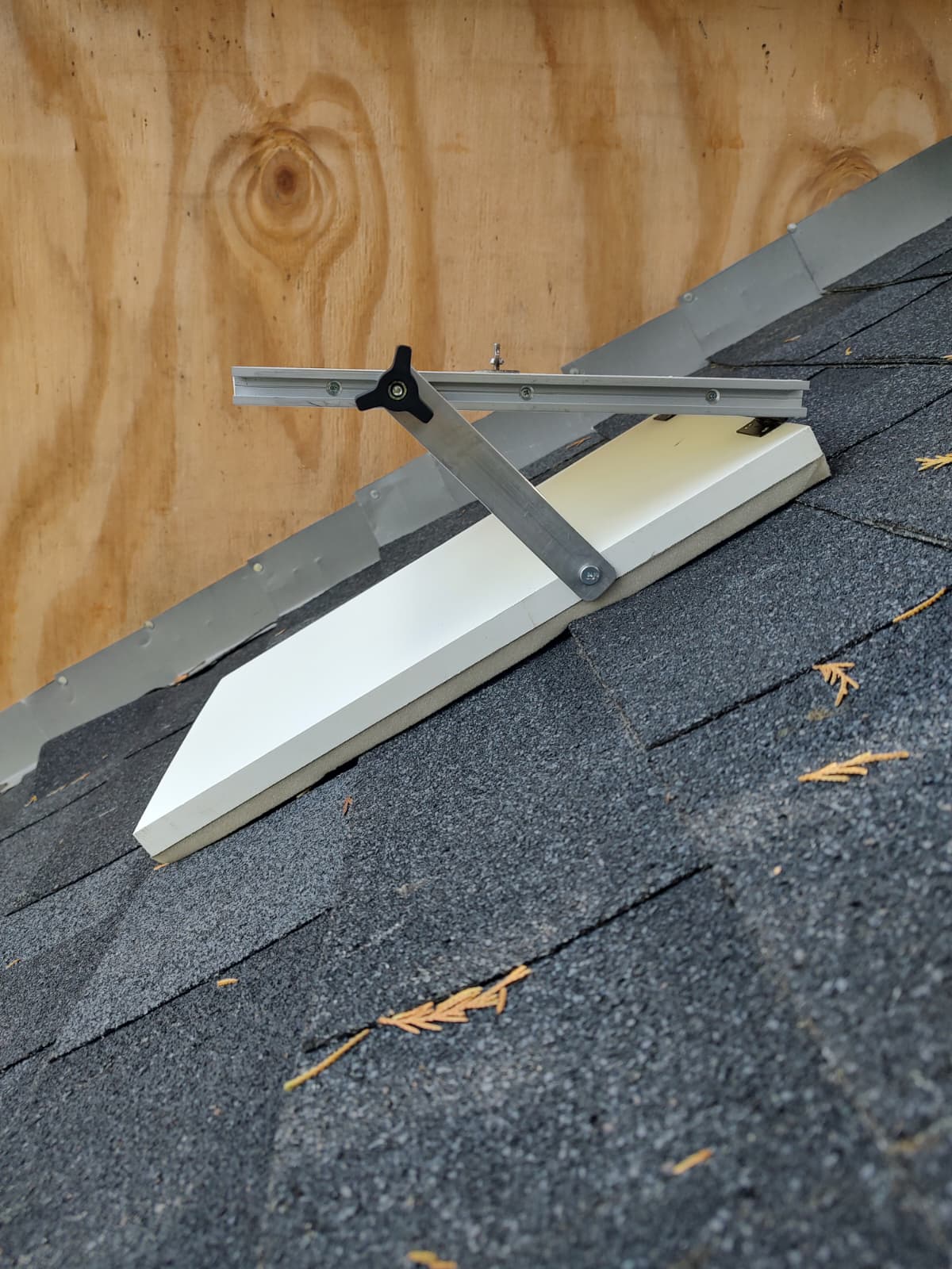 Hands placing the platform on weathered shingles